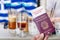 Male hand holding an european passport with a covid-19 immunity certificate over the Greek flag cold coffee background.