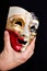 Male hand holding full face carnival mask, closeup