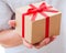 Male hand holding gift with ribbon.