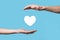 Male hand holding heart , like icon on blue background. Kindness, charity, pure love and compassion concept.Banner with copy space