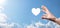 Male hand holding heart , like icon on blue background. Kindness, charity, pure love and compassion concept.Banner with copy space