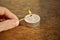 Male hand holding an ignited safety match stick before igniting white candle