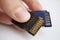 Male hand holding isolated plastic blue and black compact memory cards SD card - Secure Digital card used in cameras