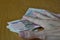 Male hand holding its fingers on Russian currency Russian Rubles on the wooden table