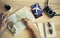 Male hand holding a magnifying glass for planning trip with world map on the table. Travel concept. Sunglasses, Passports, Paper