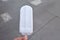 A male hand holding a melting coconut milk ice cream on wooden stick