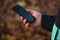 Male hand holding a mobile phone with black screen mockup