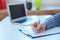 Male hand holding silver pen ready to make note in a clipboard. Businessman or employee at workplace writing business