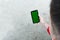 Male hand holding smartphone with blank green display for your content, man`s hand using cellphone with empty screen