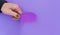 Male hand holding a speech balloon shape card on a purple background