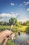 Male hand holding spinning rod on the background of the river/Spinning fishing. Male hand holds spinning rod on the background of