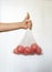 Male hand holding tomatoes in a reusable ecobag