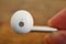 Male hand holding white modern earphone in futuristic design