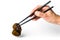 Male hand holds chopsticks with ear mushroom. Muer or jew`s ear mushroom taken with chopsticks. Edible dark fungus