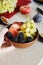 Male hand holds full fruit breakfast bowl Grapes peach blackberry figs Healthy food