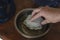 A male hand immerses a new water purification cartridge in a bowl of water