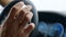 Male hand knocking fingers on steering wheel. Man putting fingers on wheel