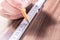 Male Hand Making A Mark At The Measuring Point Of A Folding Yardstick On A Wooden Board