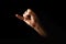 Male hand making pinky swear sign over dark background. The concept of friendship, quarrel, human relationships. copy