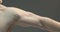 Male hand muscles. Strong muscular guy showing trained powerful biceps and triceps on gray studio background. Close up