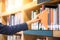 Male hand picking orange book in library