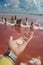 Male hand piece salt on pink water - extraction sea salt