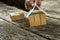 Male hand placing a paper roof on top of miniature house