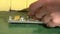 Male hand pluck large piece of cheddar cheese placed as bait in mouse trap. 4K