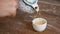 Male Hand Pouring Healthy Green Tea from Teapot in Vintage Cup on the Wooden Table. Traditional Chinese Ceremony Concept