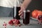 Male hand pouring pomegranate juice into a glass.