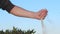 Male hand pouring sand like lost time in summer desert close up