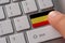 Male hand pressing keyboard button with flag of Germany on it. Online international business concept