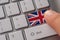 Male hand pressing keyboard button with flag of Great Britain on it. Online international business concept