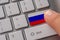 Male hand pressing keyboard button with flag of Russia on it. Online international business concept