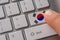 Male hand pressing keyboard button with flag of South Korea on it. Online international business concept