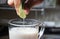 Male hand put lime in soy milk beverage