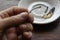 The male hand puts a burnt match in a white porcelain saucer