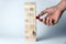 Male hand puts a cube on the tower of wooden cubes, as a symbol of support, teamwork and business development. Horizontal frame