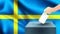 Male hand puts down a white sheet of paper with a mark as a symbol of a ballot paper against the background of the Sweden flag, sw