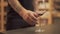 Male hand puts glass on the table and moves it closer to camera. Almost empty glass of red wine is on the desk closeup