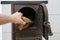 Male hand putting firewood in opened firebox