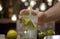 Male hand putting a glass with a tonic on the table