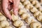 Male hand putting a hamemade dumpling to a raw of dumplings