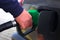 Male hand refilling the car with fuel pistol on a filling Station