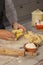 Male hand seen making pasta with dough roller and flour on kitchen counter