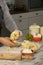 Male hand seen making pasta with dough roller and flour on kitchen counter