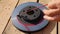 Male hand slowly removes red duct tape from painted car brake disc. FullHD