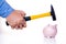 Male hand smashes a pink pig piggy bank with a hammer on a white background. The concept of savings and savings