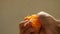 Male hand squeezing fresh orange juice in slow motion. Hand squeezing orange.