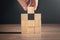 Male hand stacking wooden empty cubes